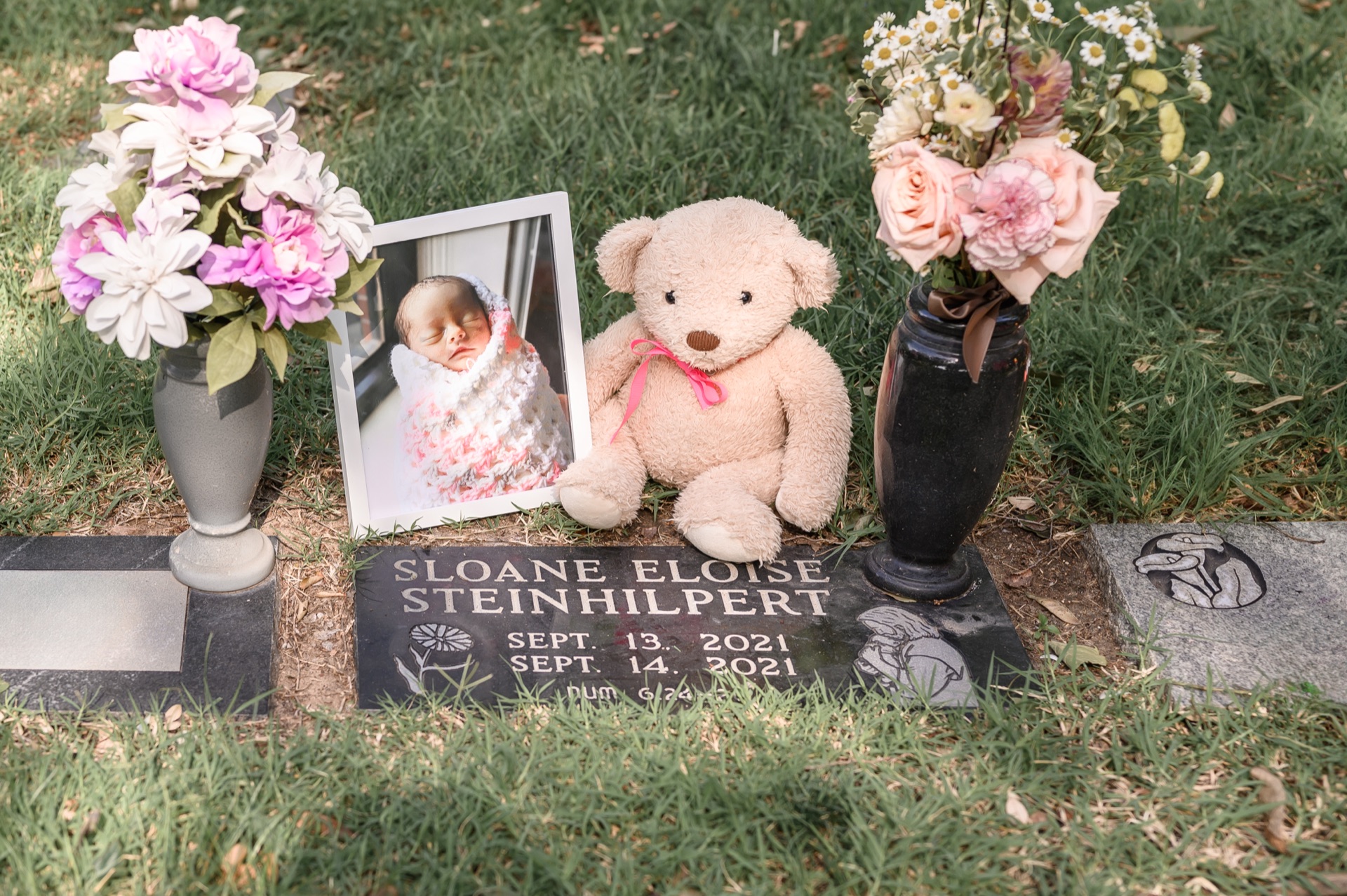 Tributes and flowers placed by the grave of an infant girl