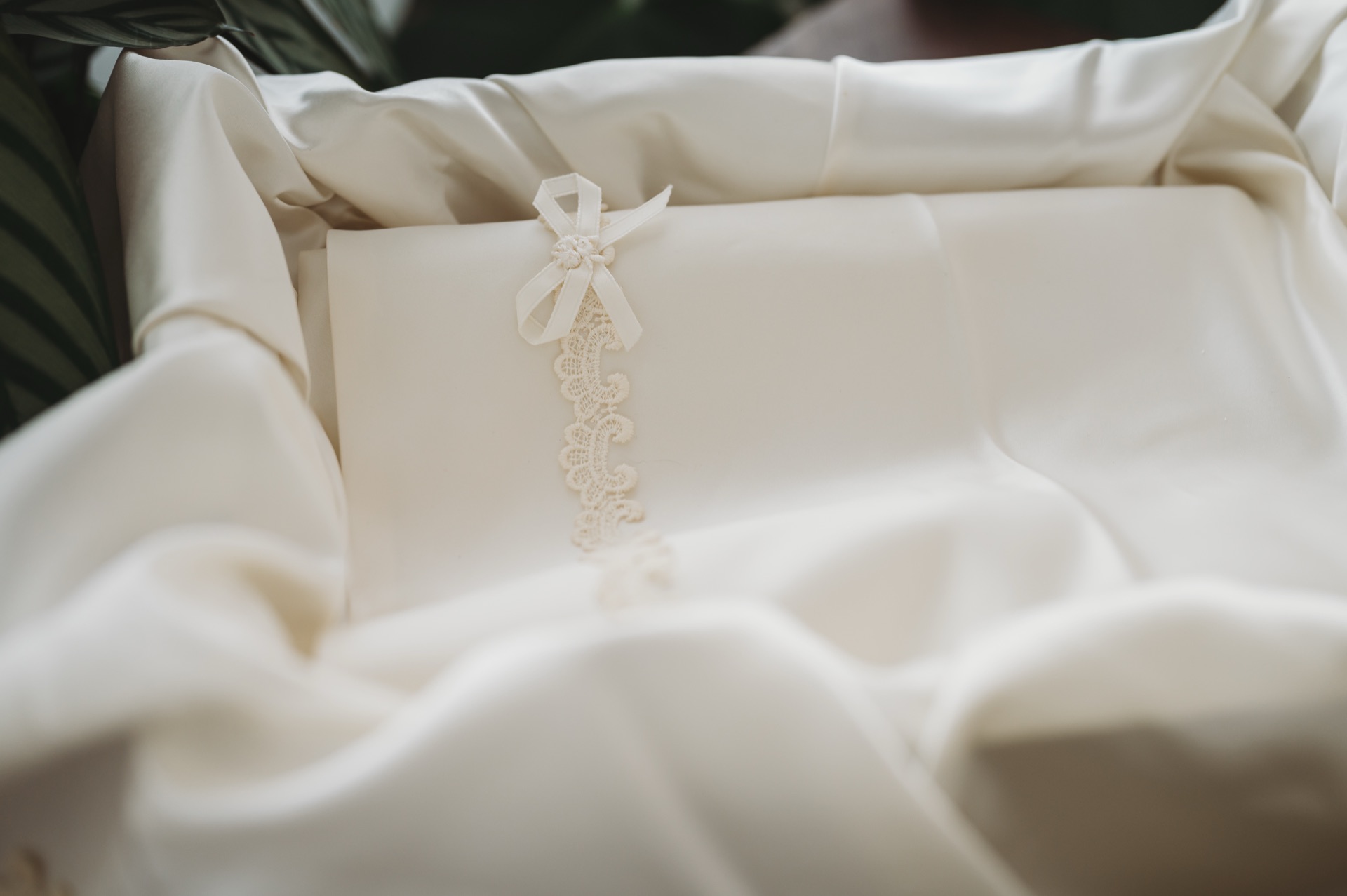 White ribbon and lace inside a beige casket