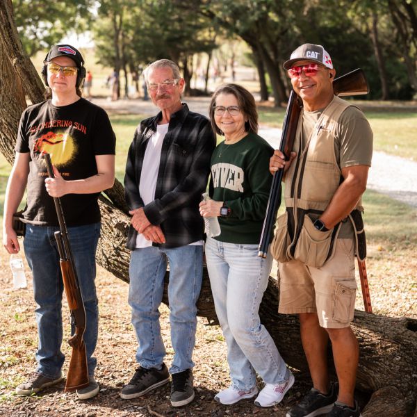 Four_people_with_clay_shoot_standing_together_outdoors