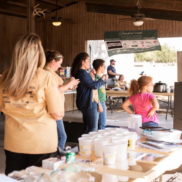 Group_of_people_gathered_around_table_under_pavilion