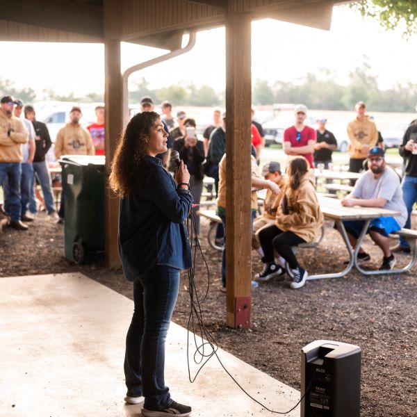 Lady_speaking_to_crowd_under_gazebo_during_day