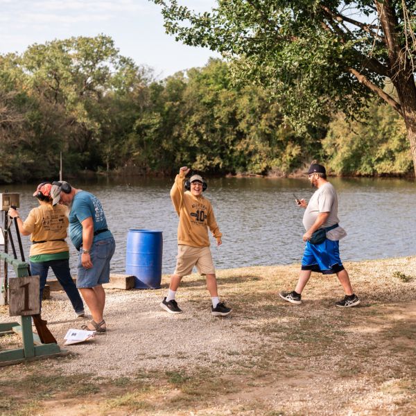 Men_clay_shooting_outside_near_lake