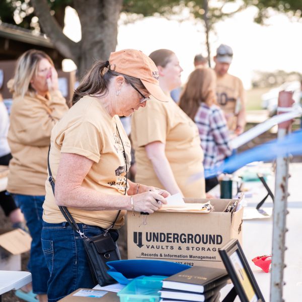 Outdoor_event_volunteer_writing_at_table_with_boxes