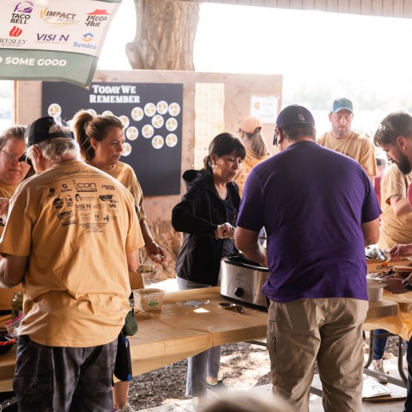 People_gathering_around_food_at_outdoor_table