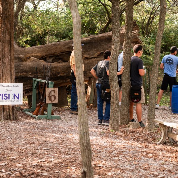 People_standing_in_woods_watching_clay_shoot