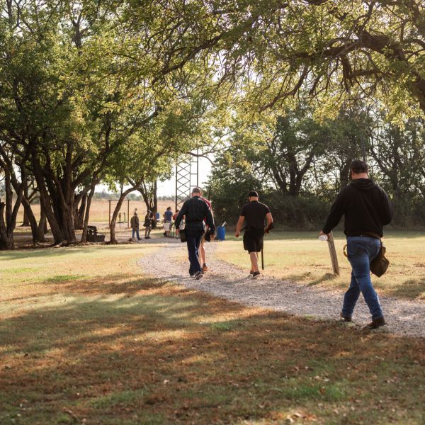 People_walking_dirt_path_under_trees