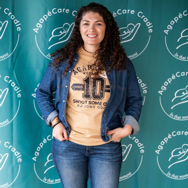 Woman_posing_for_photo_against_backdrop_with_logo