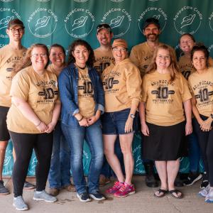 Agape_team_at_event_wearing_yellow_shirts_smiling