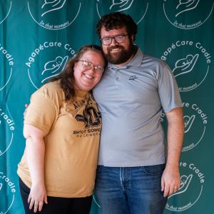 Couple_hugging_at_event_with_blue_backdrop