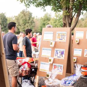 Man_standing_at_outdoor_raffle_with_poster_board